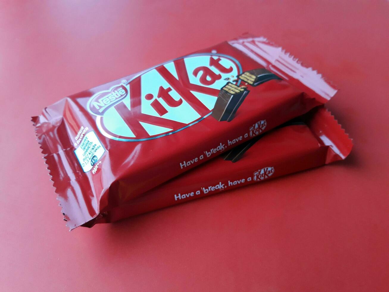 KHARKIV, UKRAINE - JANUARY 2, 2021 Kit Kat by Nestle chocolate covered wafer on bright color photo