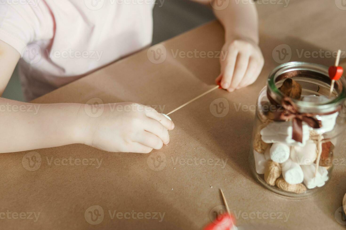 Children's hands collect a sweet gift for Valentine's Day. A gift for the holiday, a video blog entry. photo