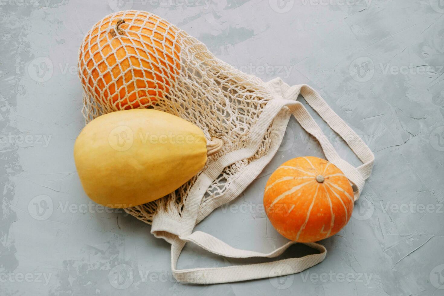 Mesh shopping bag with vegetables. Autumn pumpkin harvest photo