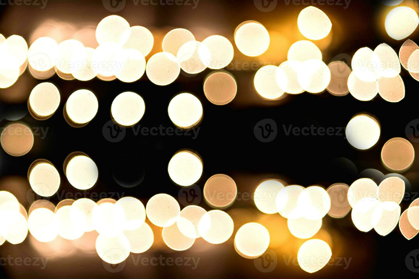 Blurry garland lights on a dark background. Festive Christmas and New Year background. Soft focus photo