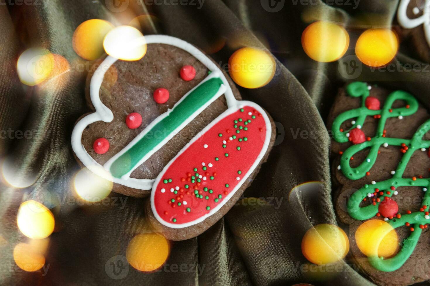 Banner for Christmas and New Year gingerbread. Christmas trees, toys, snowmen, garlands on a background of brown silk fabric. Bright bokeh. photo