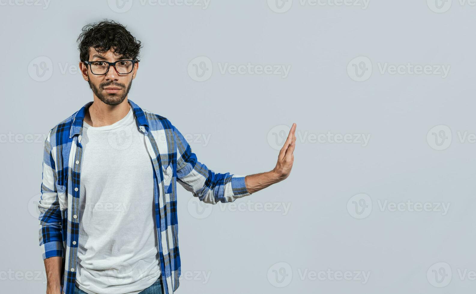 Displeased young man rejecting with rejection gesture, throw palms isolated. Displeased person with rejection gesture isolated, pulls palms in rejection, frowns in disgust photo