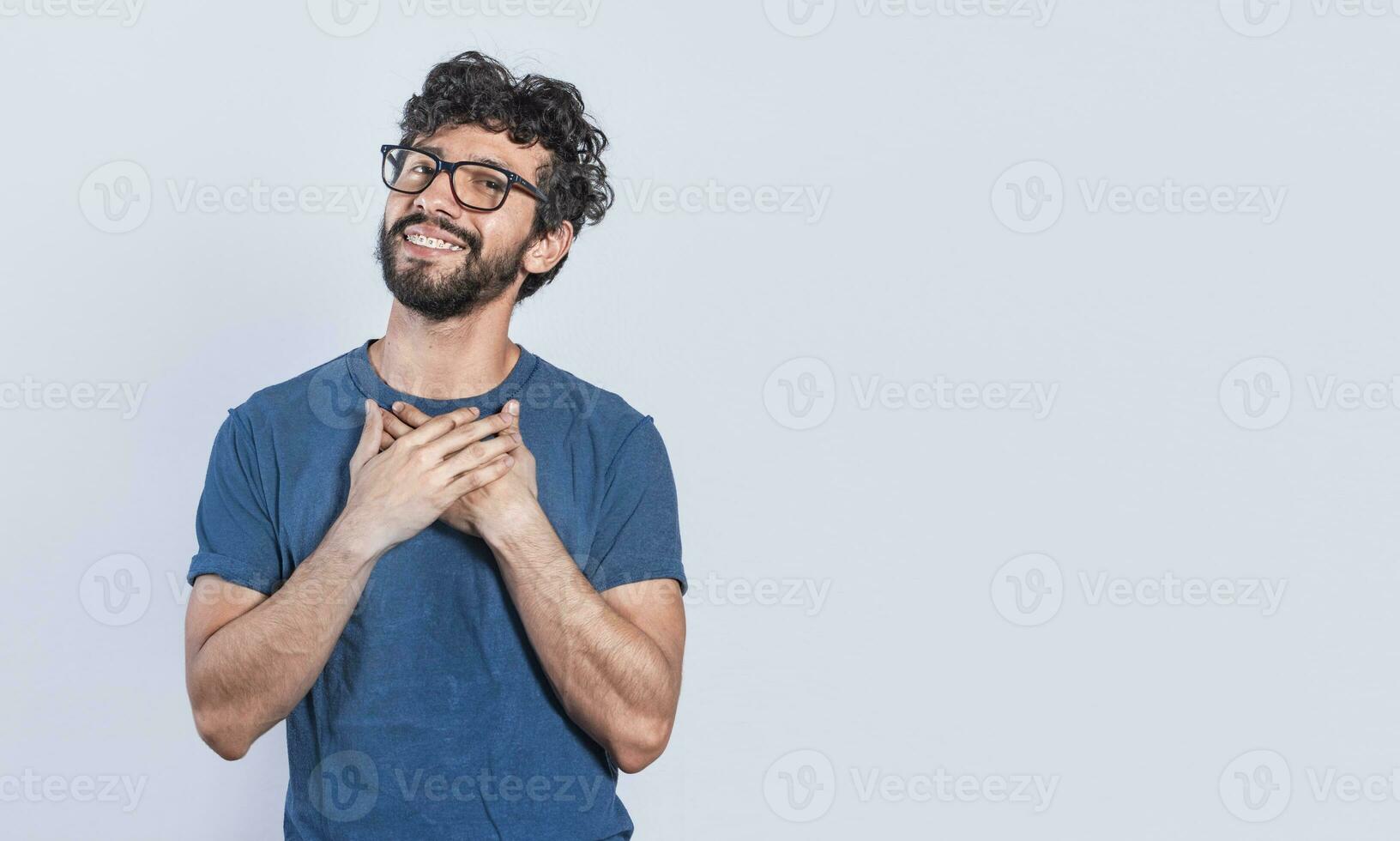 Grateful people smiling with hands on chest. Positive looking friendly handsome man with charming sincere smile feeling thankful, relaxed person with thanks gesture with hands on chest. photo