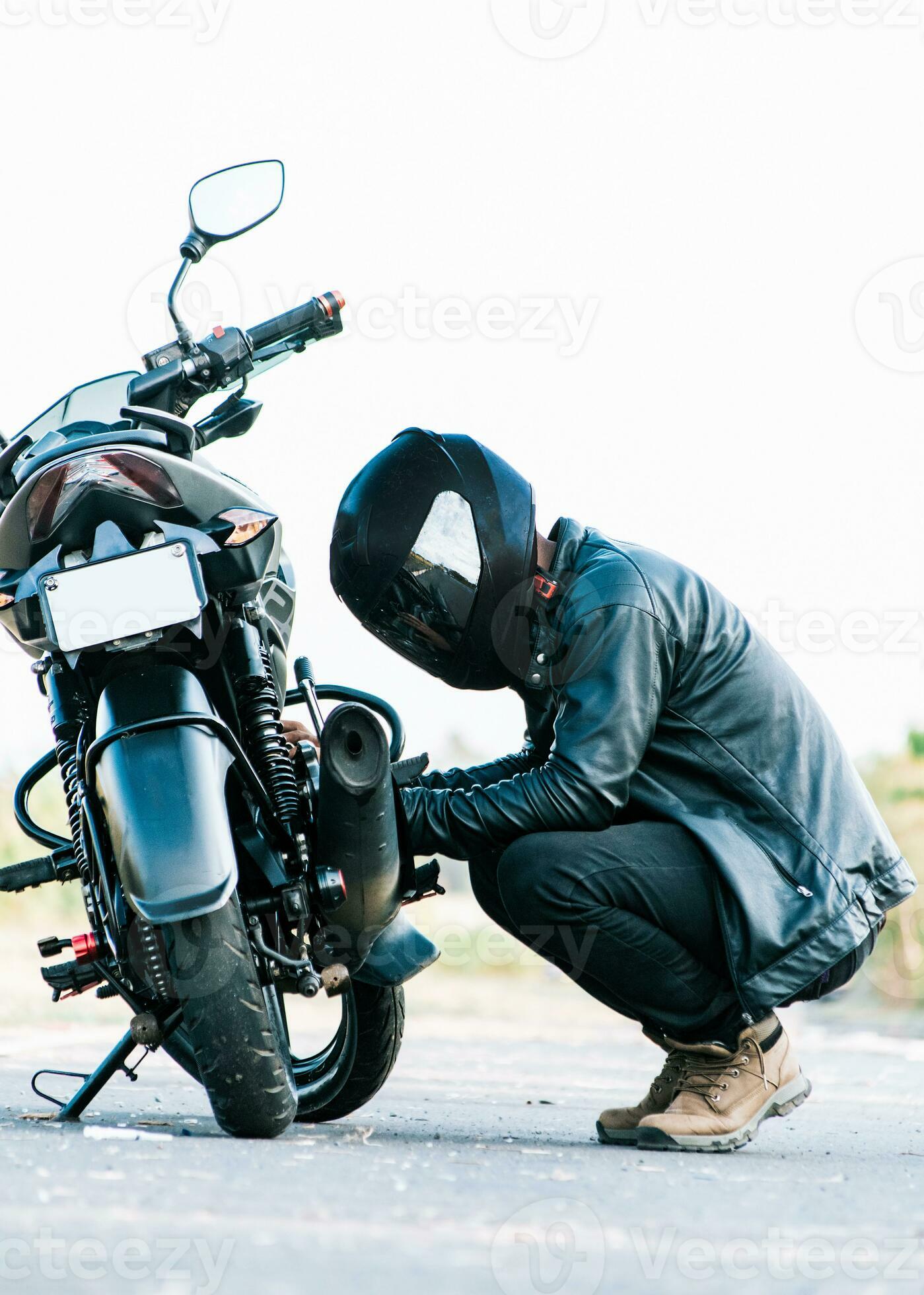 hombre comprobación su motocicleta en el la carretera. motociclista  fijación el motocicleta en el camino, motorista reparando motocicleta en el  la carretera 33857132 Foto de stock en Vecteezy