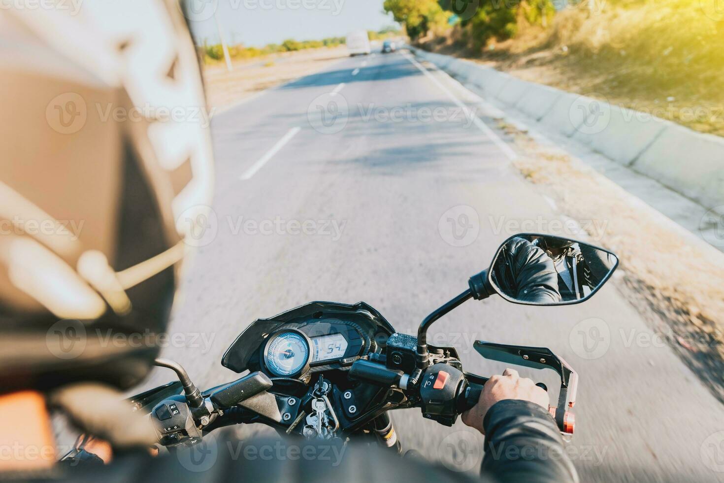 View of hands of biker driving his motorbike. Close up of motorcyclist driving his motorbike on the street photo
