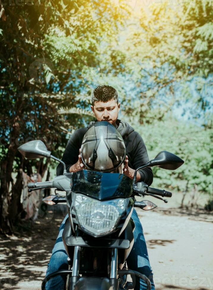 Motorcyclist putting on safety helmet, Biker motorcycle safety concept. Young motorcyclist man putting on safety helmet, Man on motorcycle putting on helmet photo