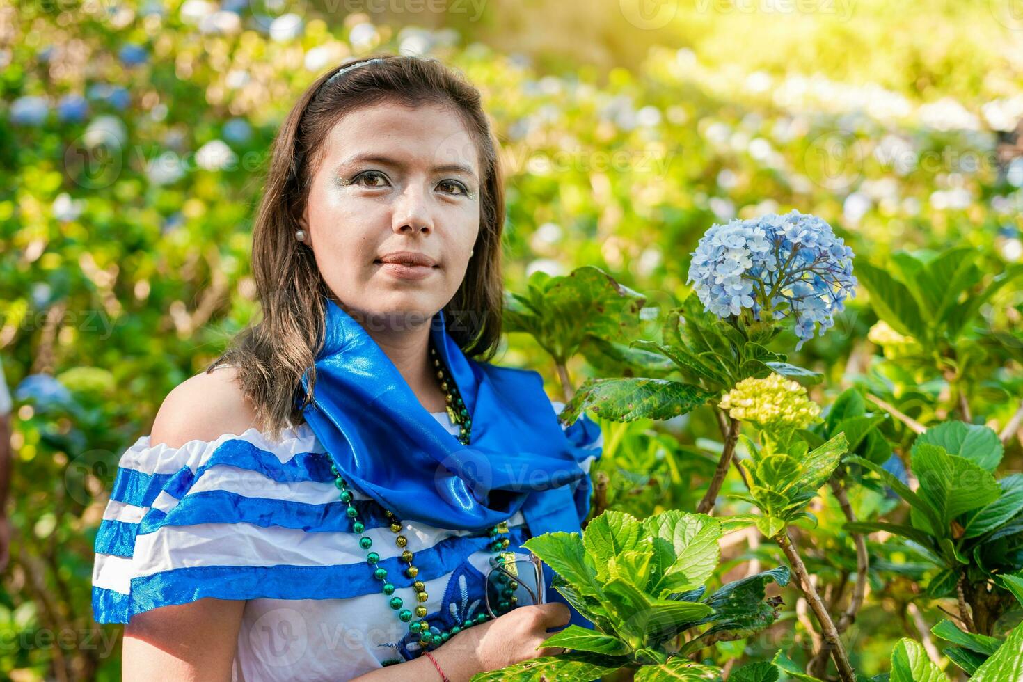 Portrait of smiling woman in national folk costume in a field of flowers. Nicaraguan national folk costume, Young Nicaraguan woman in traditional folk costume in a field of Milflores photo