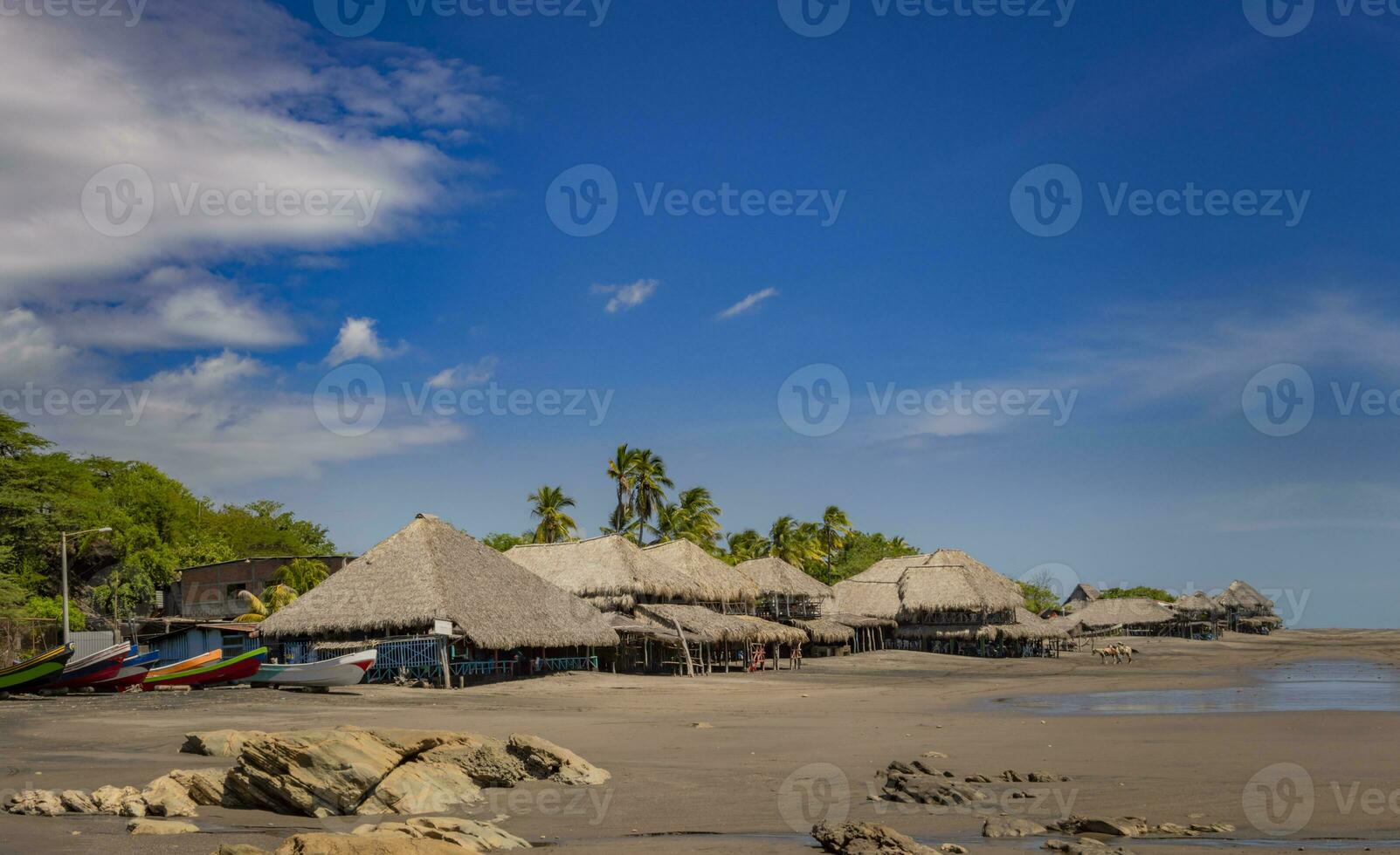 Thatched roof restaurants near the beach, thatched roof restaurant near wooden boats with blue sky, nicaragua restaurants near the beach photo