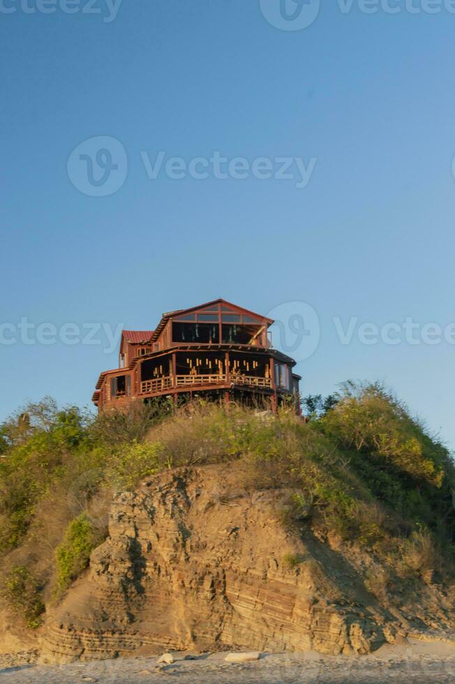 bungalow near the beach, beach restaurant on hill, concept of a house on the rock photo