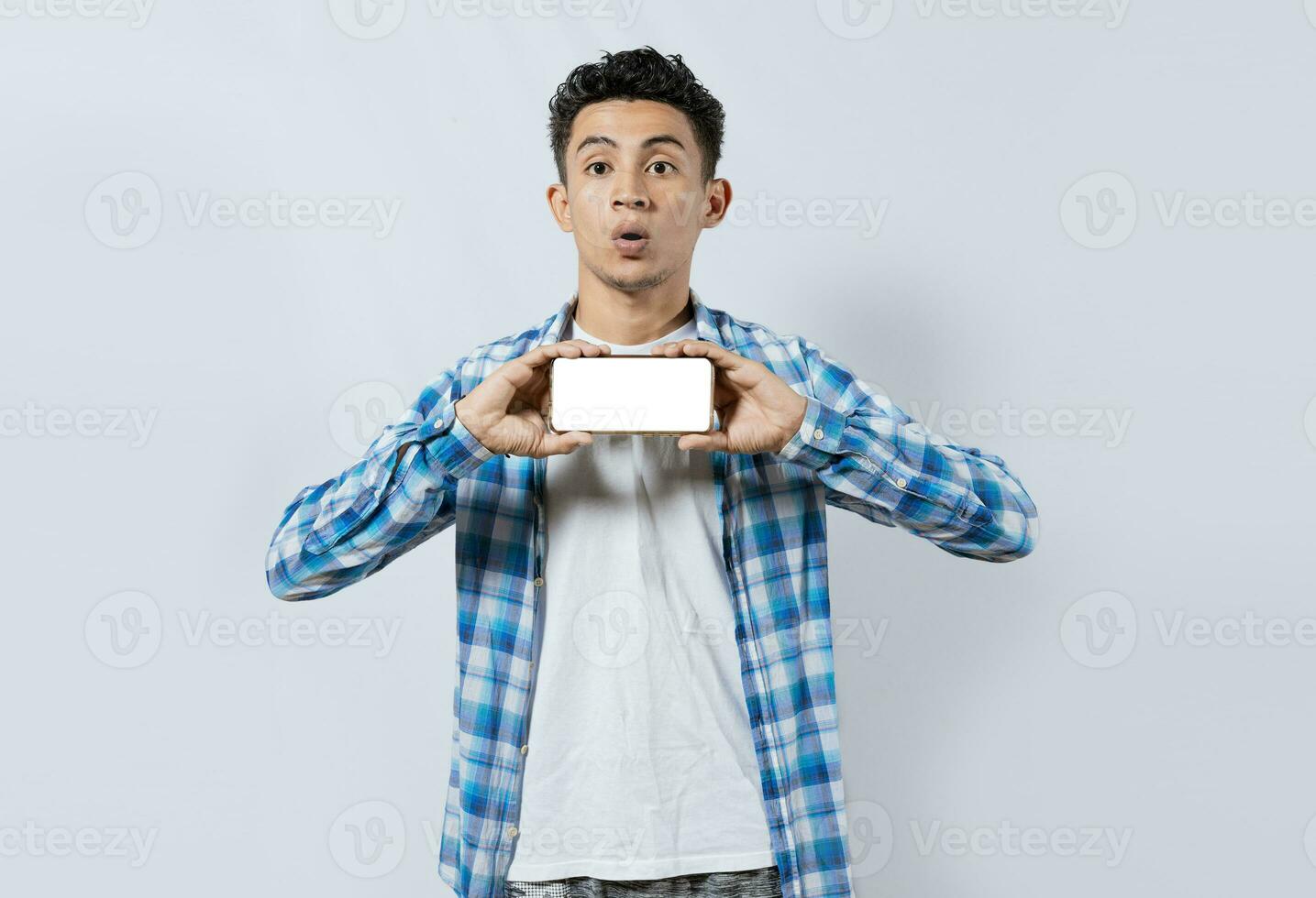 asombrado joven hombre demostración anuncio en Teléfono móvil. sorprendido hermoso hombre demostración el horizontal pantalla de su célula teléfono, sorprendido chico en lentes demostración blanco pantalla de inteligente teléfono foto