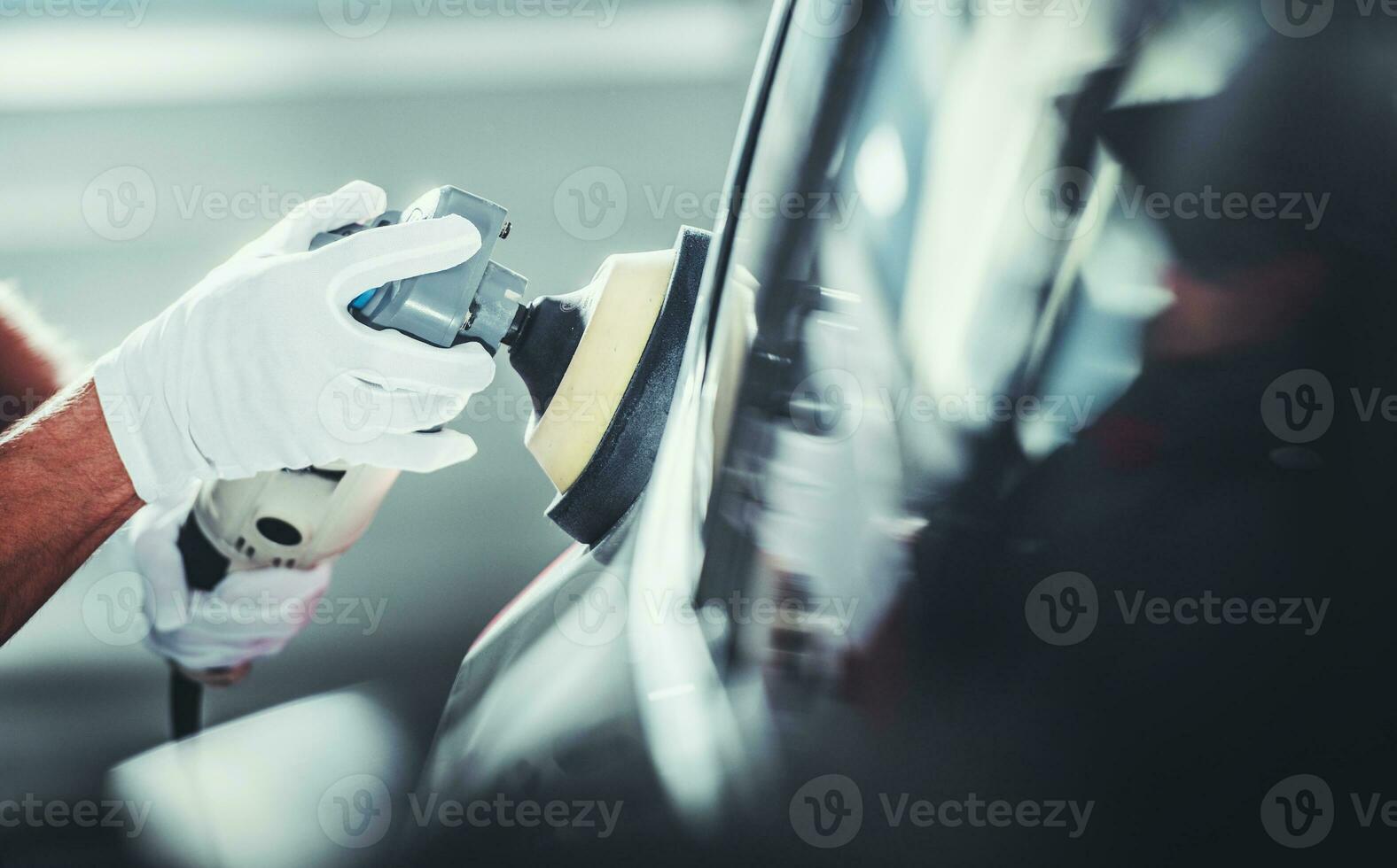 Automotive Worker Polishing Vehicle Body After Waxing photo