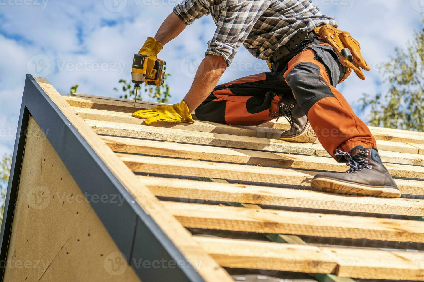 Roofing Contractor Attaching Wooden Elements to the House Roof photo