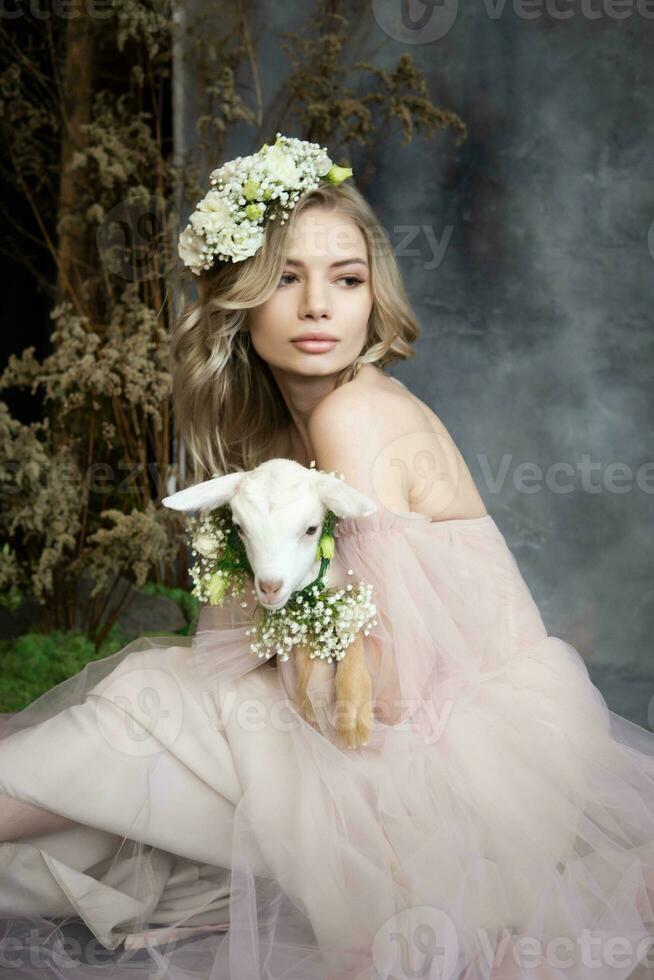 A young blonde woman in an airy pink dress with a white kid. Spring portrait of a woman. photo