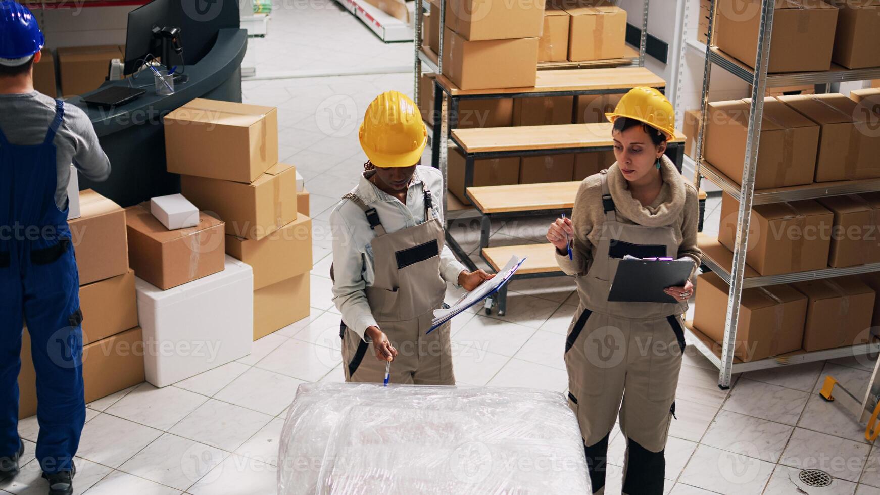 Depot workers planning shipment and distribution in warehouse space, analyzing list of stock inventory. Storage room manager organizing industrial goods in cardboard boxes, small business. photo