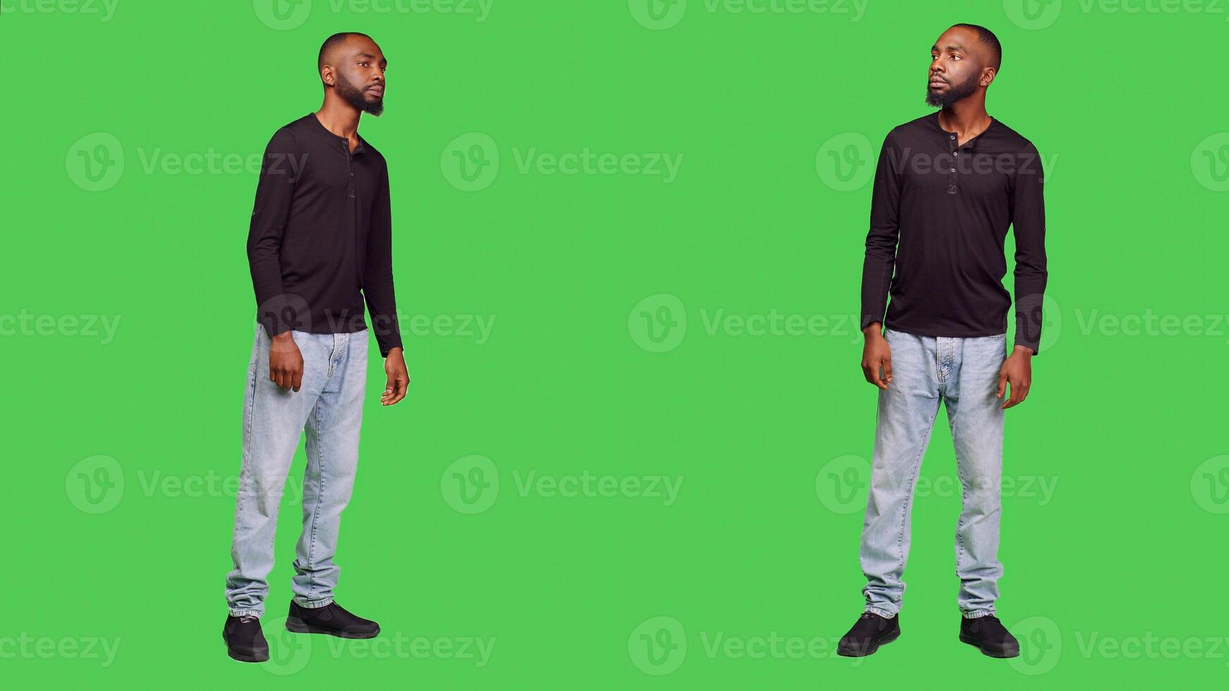 Relaxed friendly person smiling in front of camera, feeling positive and confident over full body green screen background. Young man being cheerful and optimistic standing in studio. photo