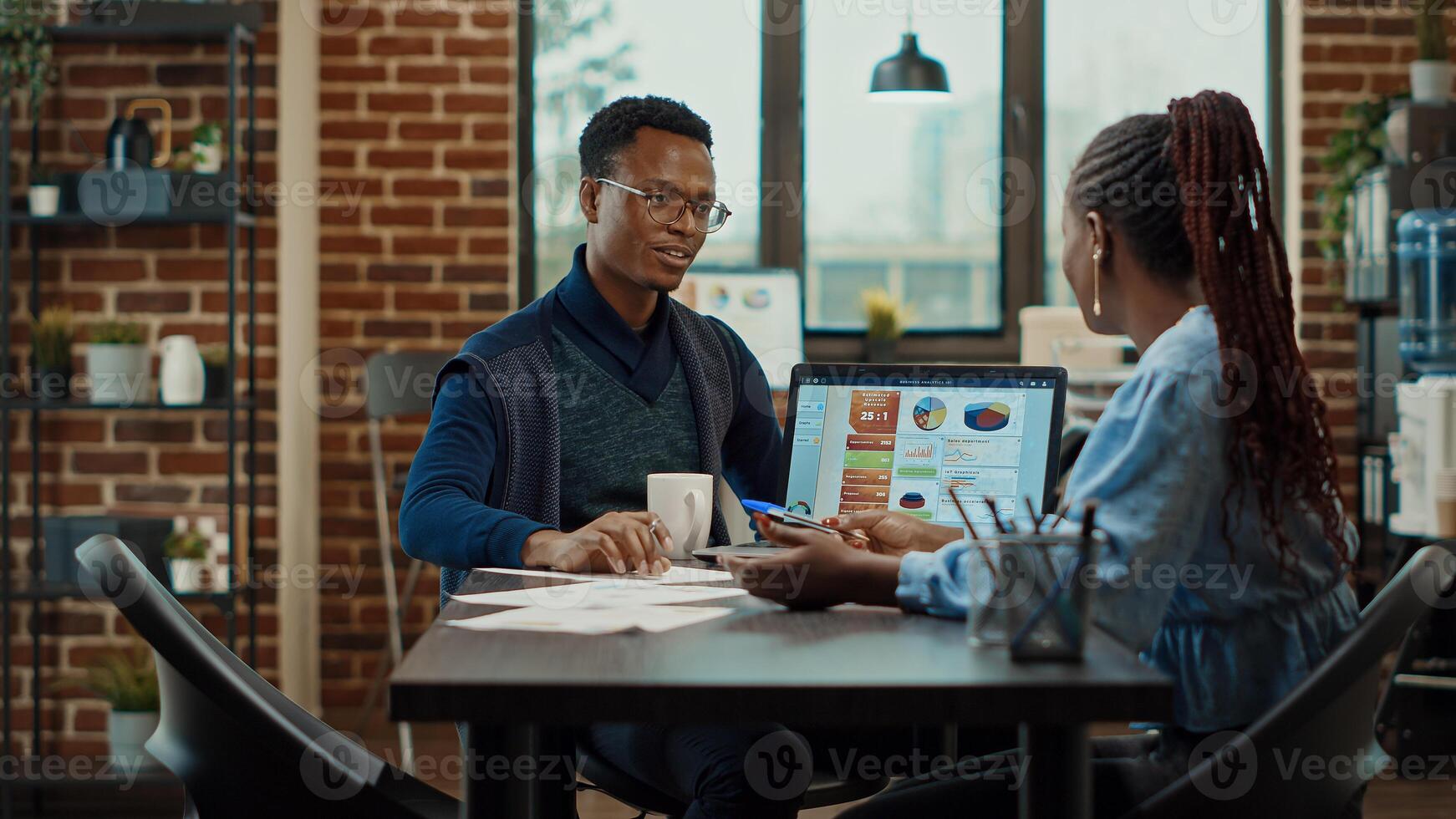 Business team discussing new strategy in boardroom office space, looking at data analytics on laptop. Brainstorming ideas to find startup development solutions, documents reports. photo
