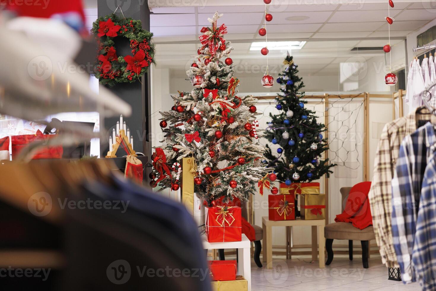During winter holiday season, Christmas ornaments is waiting for shoppers seeking presents in clothing store. Items for sale decorate shopping center designer shop for xmas event. photo