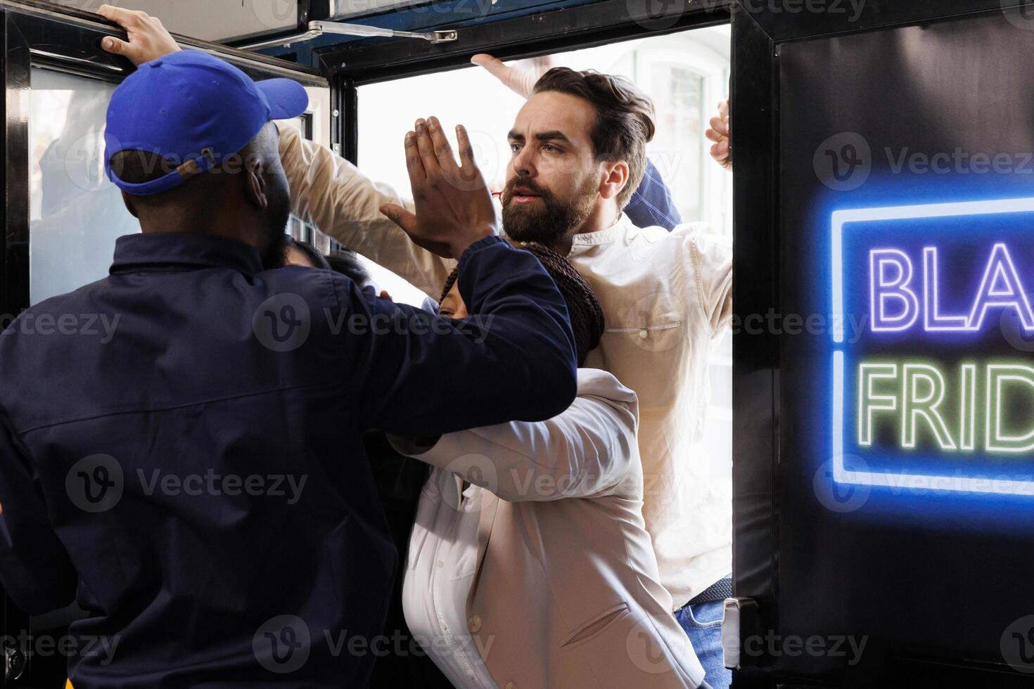 Crazy Black Friday shoppers breaking down door, trying to get inside store before it opens. Frenzy people customers fighting with security guard, behaving rude while shopping during sales photo