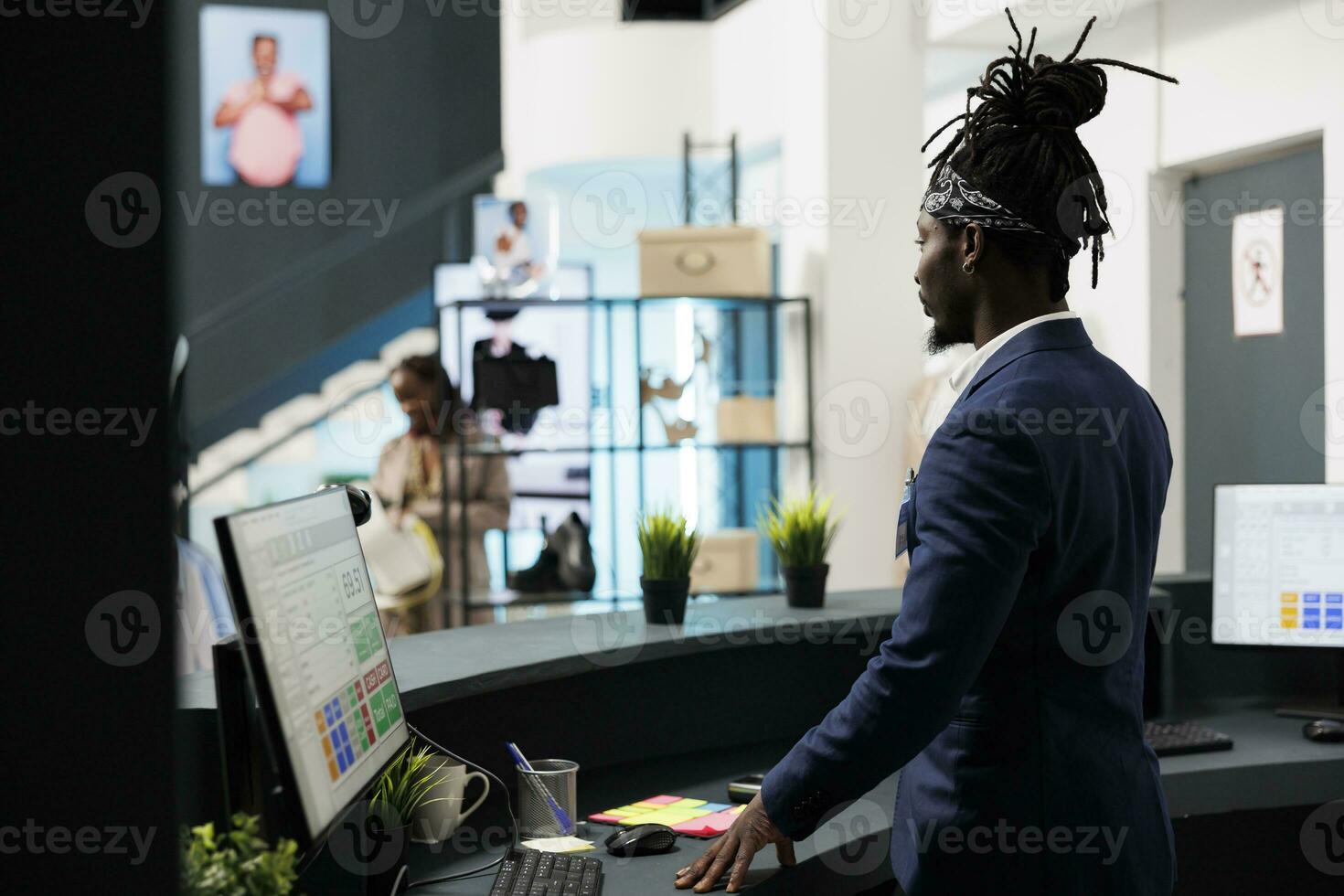 Shopping store worker standing at cash register, analyzing financial profit on computer in shopping centre. Stylish employee preparing fashionable clothes for clients packages. Fashion concept photo