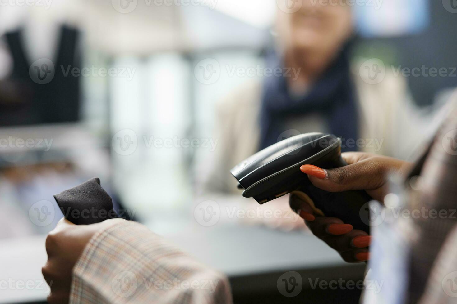 africano americano trabajador exploración de moda camisa utilizando Tienda escáner, preparando compra para mayor adicto a las compras mujer. cliente comprando casual vestir en ropa almacenar, comercial actividad. cerca arriba foto