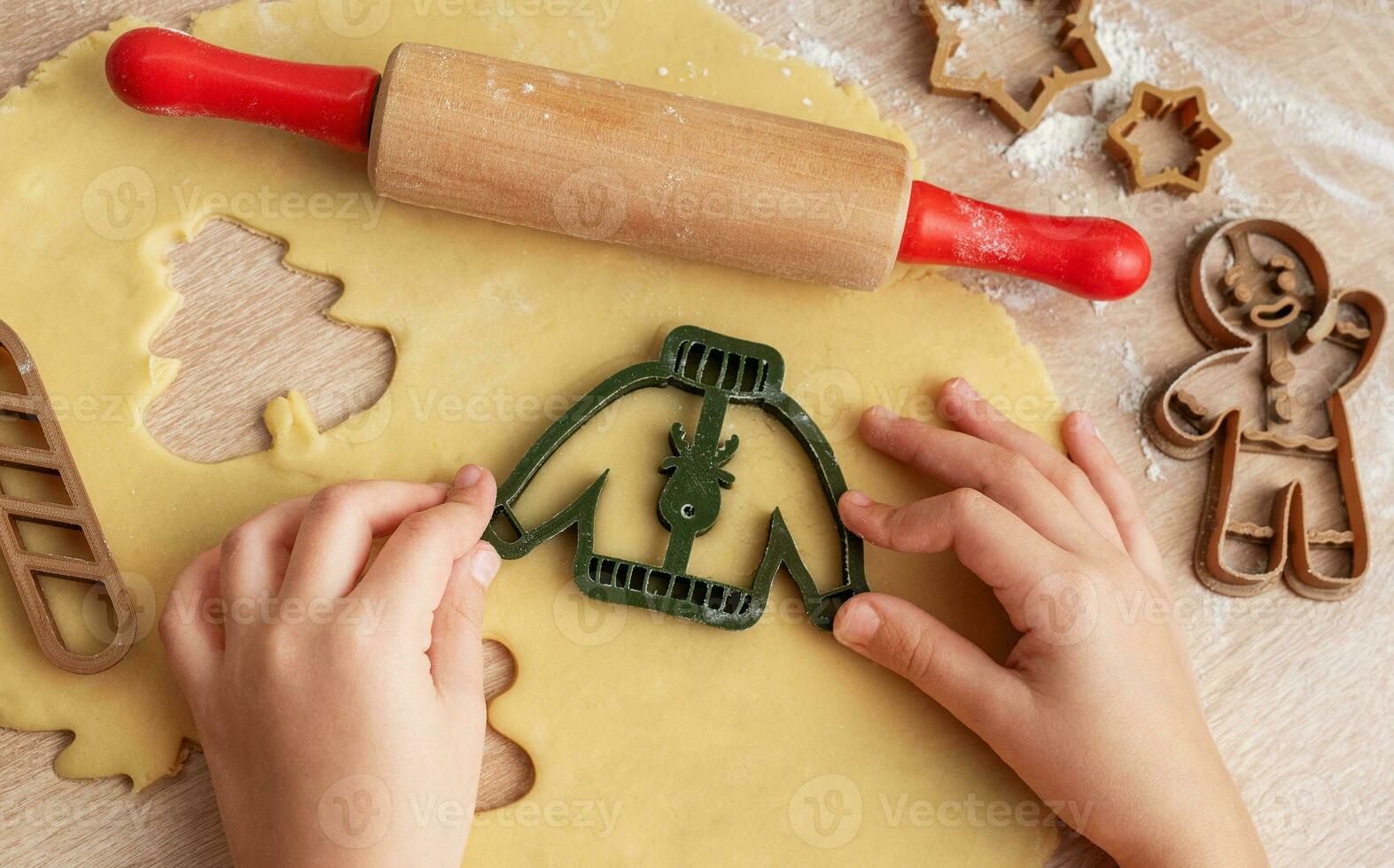 Children's hands with gingerbread cookies on wooden background photo