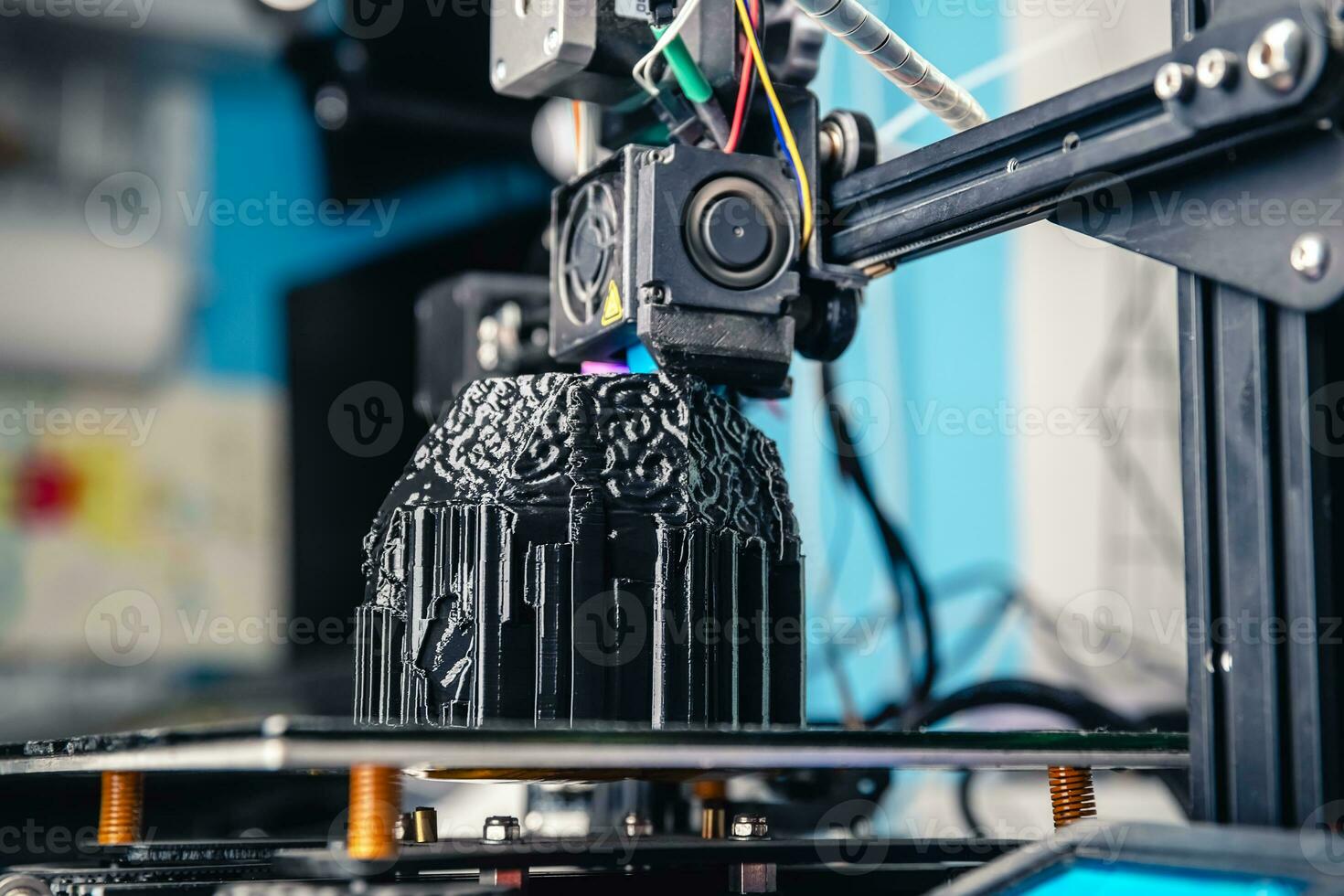 A 3D printer prints a black model. Technology at home photo