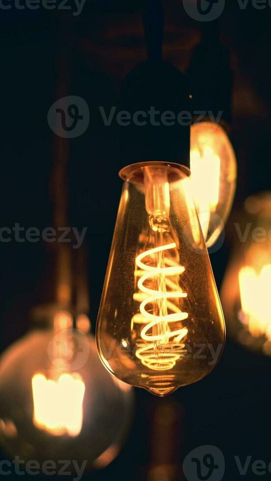 Spiral Retro light bulbs hanging on a dark background. Electricity, Vintage photo