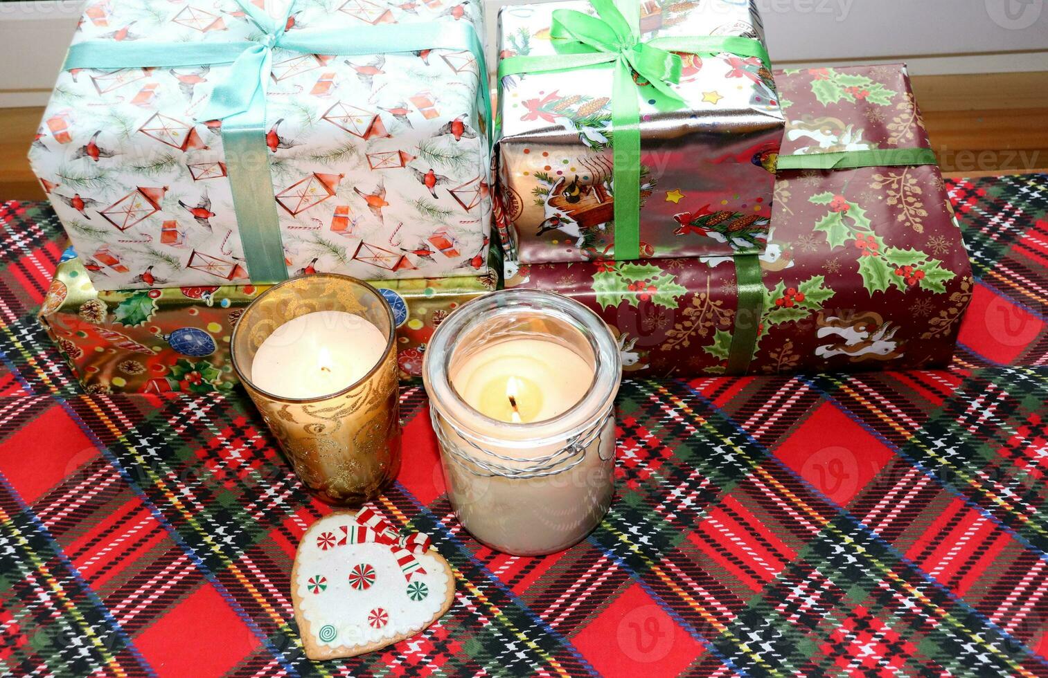 Navidad regalos en cajas y ardiente velas en vaso candelabros con pan de jengibre en un crucian a cuadros Manteles, horizontal foto, parte superior ver foto