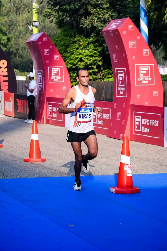 nuevo Delhi, India - octubre 15 2023 - vedanta Delhi medio maratón carrera después codicioso en cuales maratón Participantes acerca de a cruzar el terminar línea, Delhi medio maratón 2023 foto