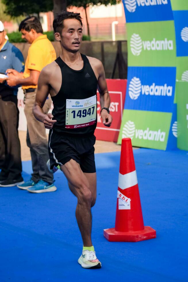 New Delhi, India - October 15 2023 - Vedanta Delhi Half Marathon race after covid in which marathon participants about to cross the finish line, Delhi Half Marathon 2023 photo