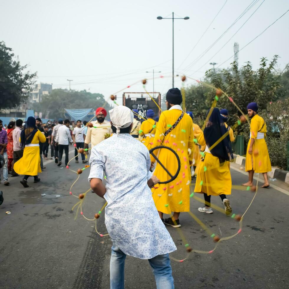 Delhi, India, October 2, 2023 - Sikhs display gatka and martial arts during annual Nagar Kirtan, Traditional, procession on account of birthday of Guru Nanak Dev ji, Nagar Kirtan in East Delhi area photo