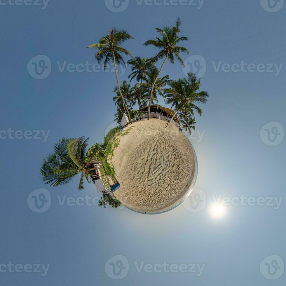coconut trees in jungle in Indian tropic village on sea shore on little planet in blue sky, transformation of spherical 360 panorama. Spherical abstract view with curvature of space. photo