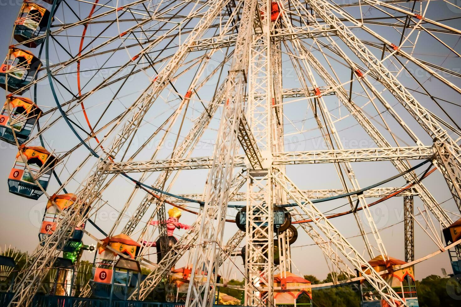 Closeup of multi-coloured Giant Wheel during Dussehra Mela in Delhi, India. Bottom view of Giant Wheel swing. Ferriswheel with colourful cabins during day time. photo