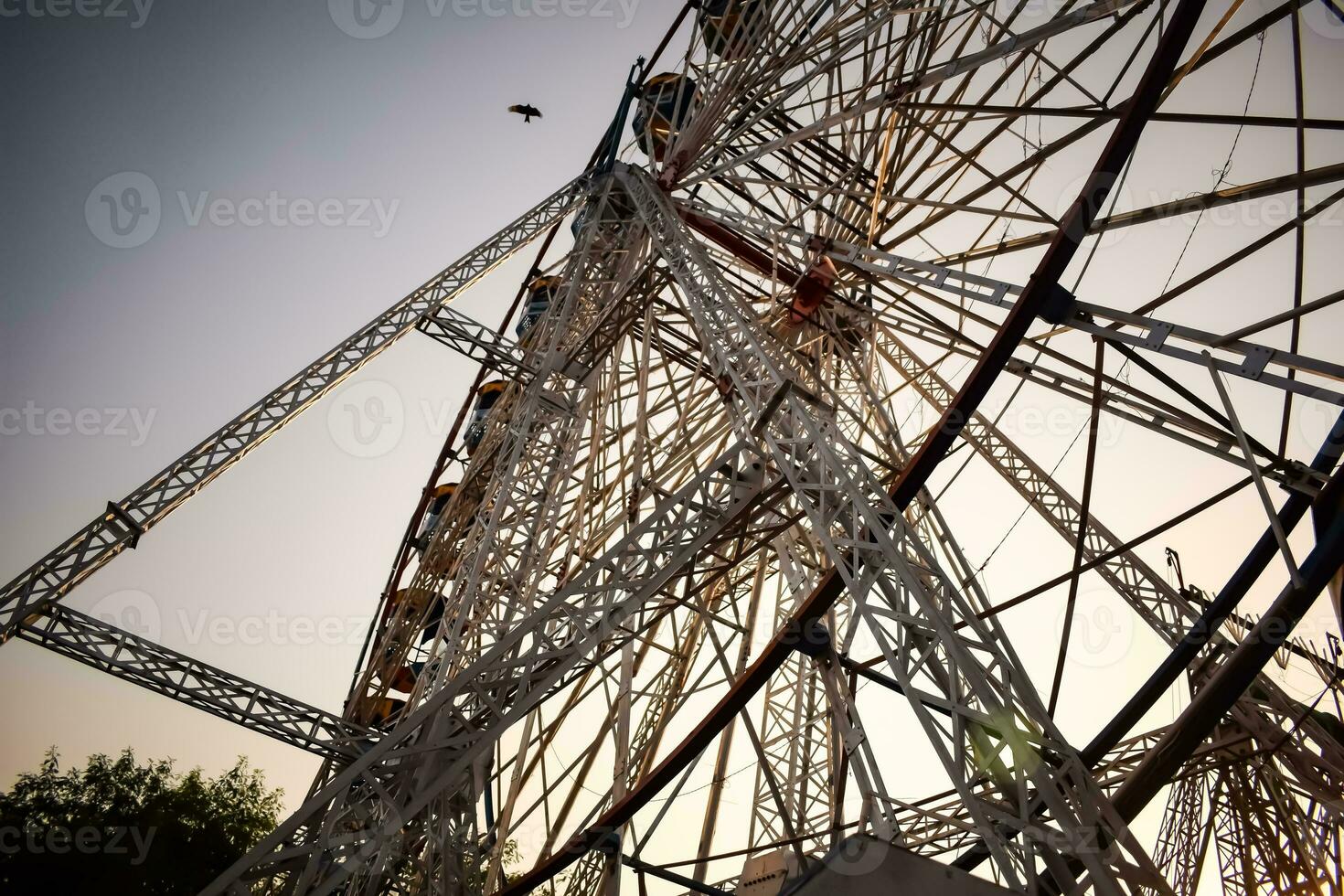 Closeup of multi-coloured Giant Wheel during Dussehra Mela in Delhi, India. Bottom view of Giant Wheel swing. Ferriswheel with colourful cabins during day time. photo