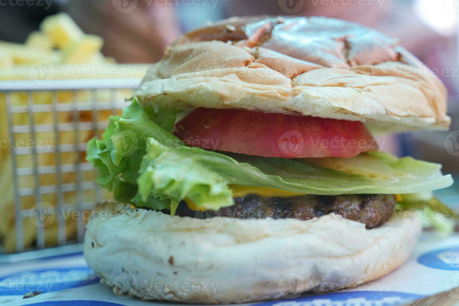 Cheeseburger With Salad And Tomato On a wooden board photo