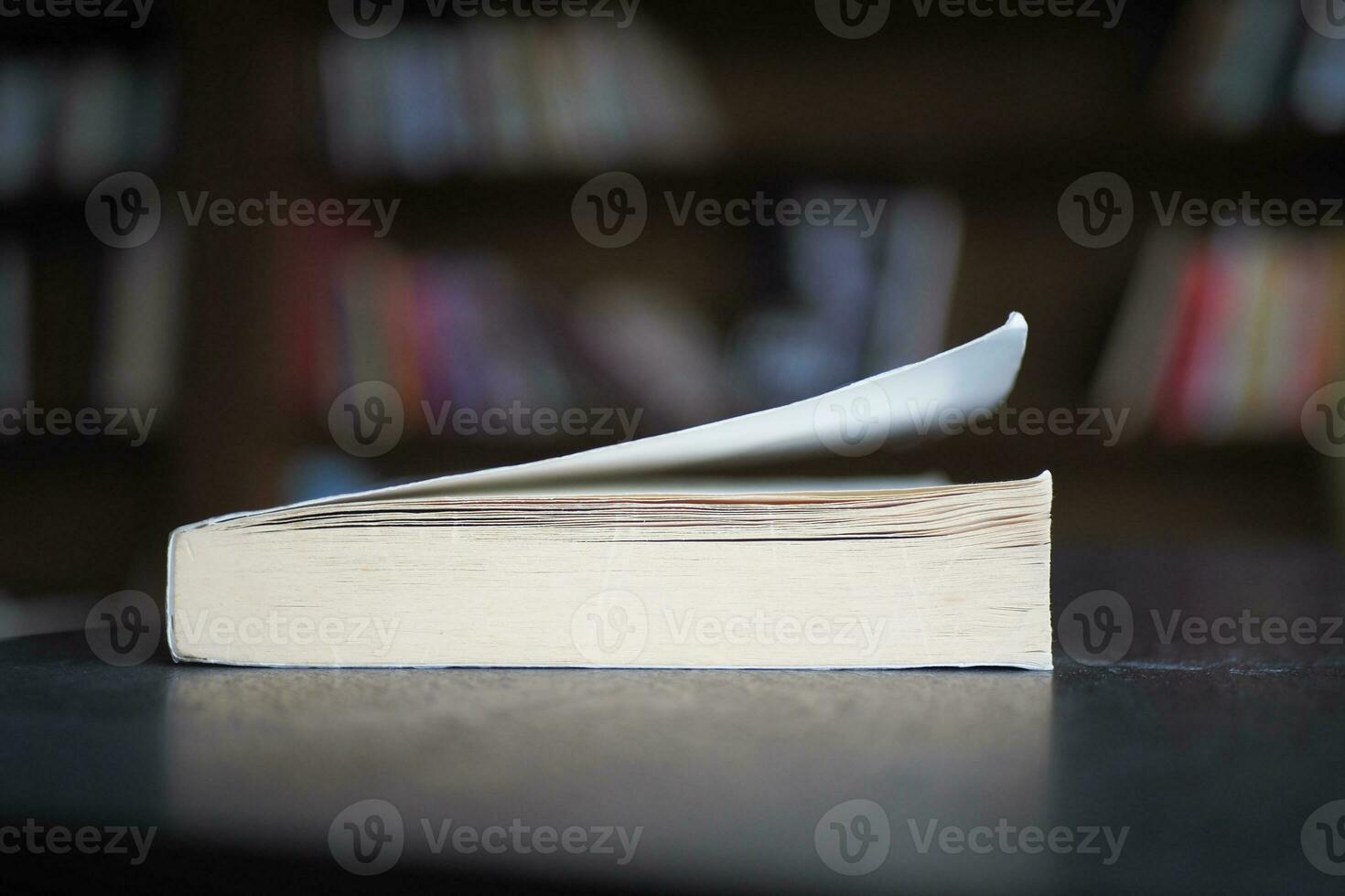 open book and a pencil on wooden table photo