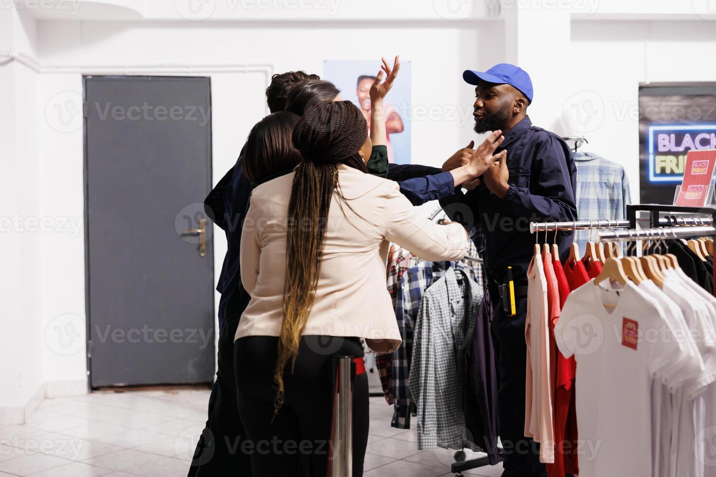 African American man, security officer talking and calming down Black Friday shoppers wait in line at clothing shop entrance. People shoppers arguing with clothes store staff, holiday shopping madness photo