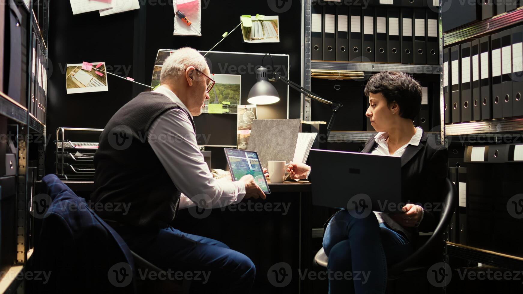 Inspectors team reading case files to conduct private investigation, clandestine operation. Experienced officer and criminal expert discussing about crime suspect, detective work. photo