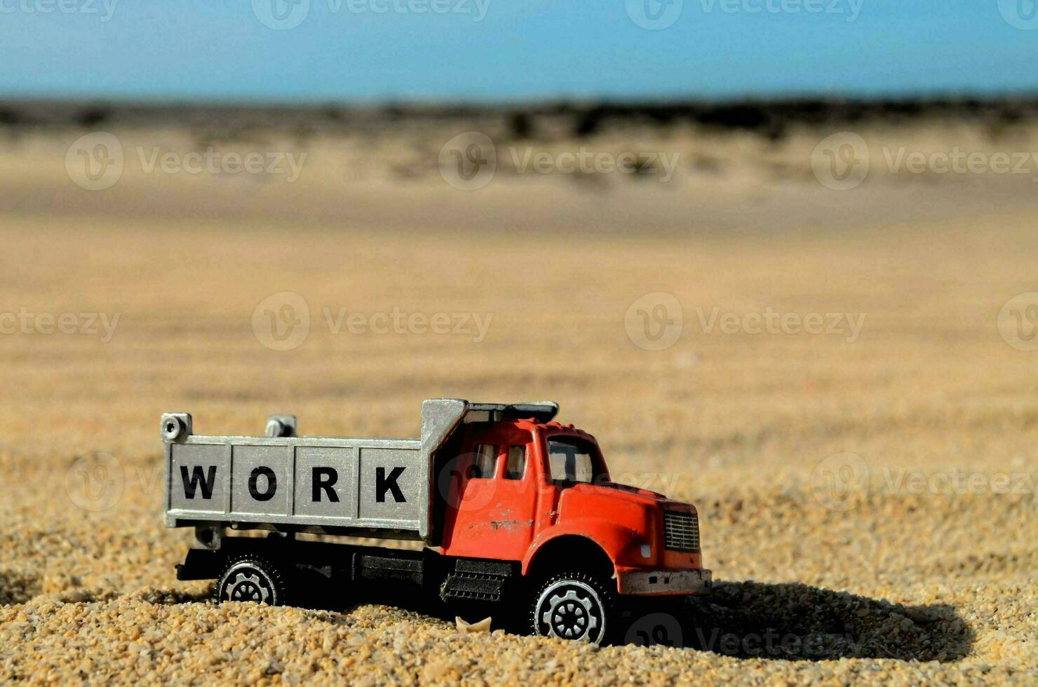 a toy truck is sitting in the sand photo