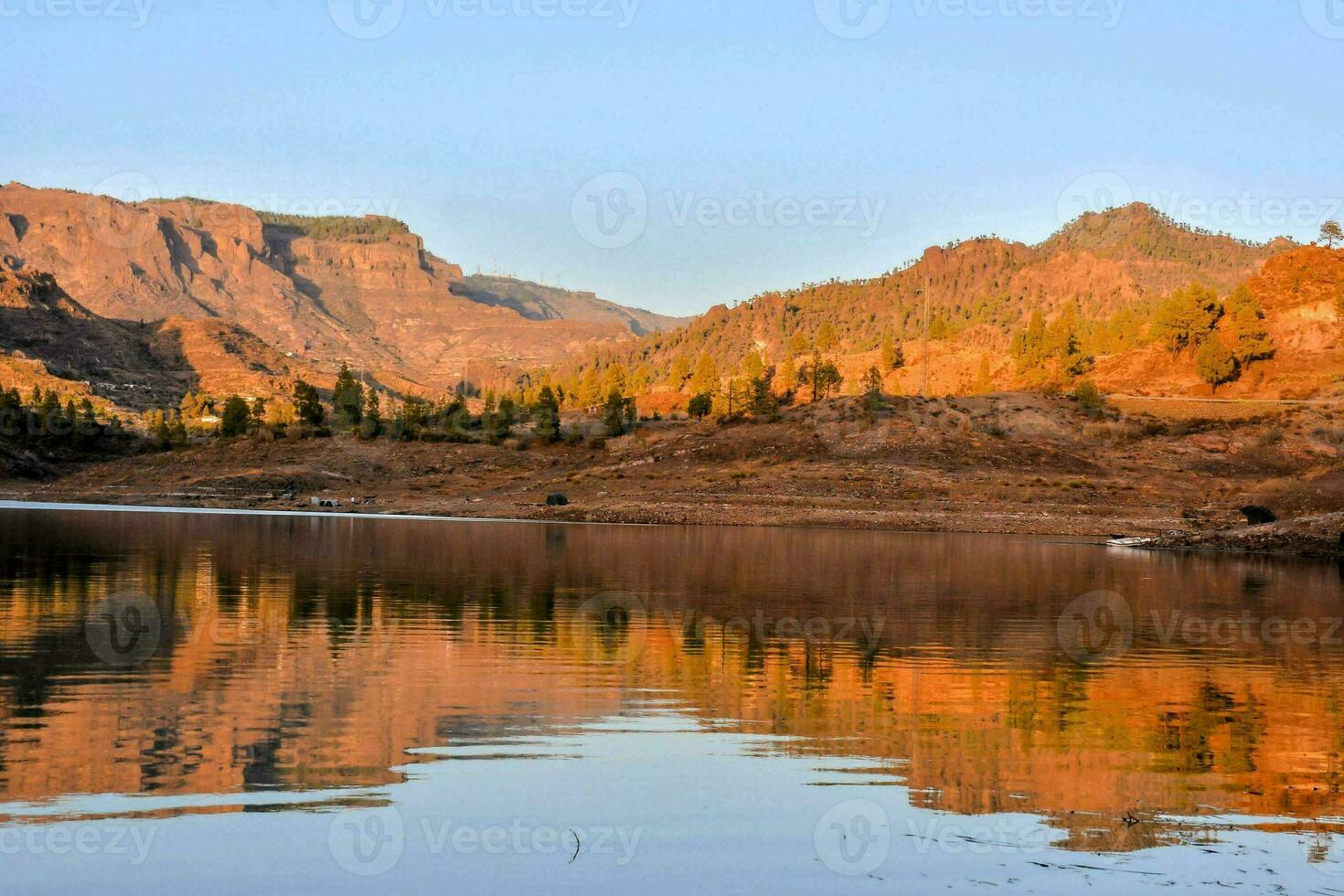un lago rodeado por montañas y un azul cielo foto