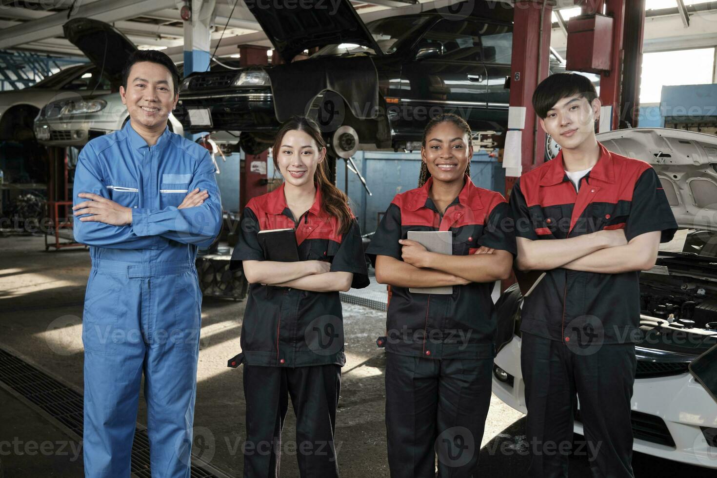 retrato de multirracial profesional mecánico equipo brazos cruzado y Mira a cámara, trabajo a coche Servicio cochera, contento mantenimiento trabajos, cheque y reparar ocupación en automotor industria negocio. foto