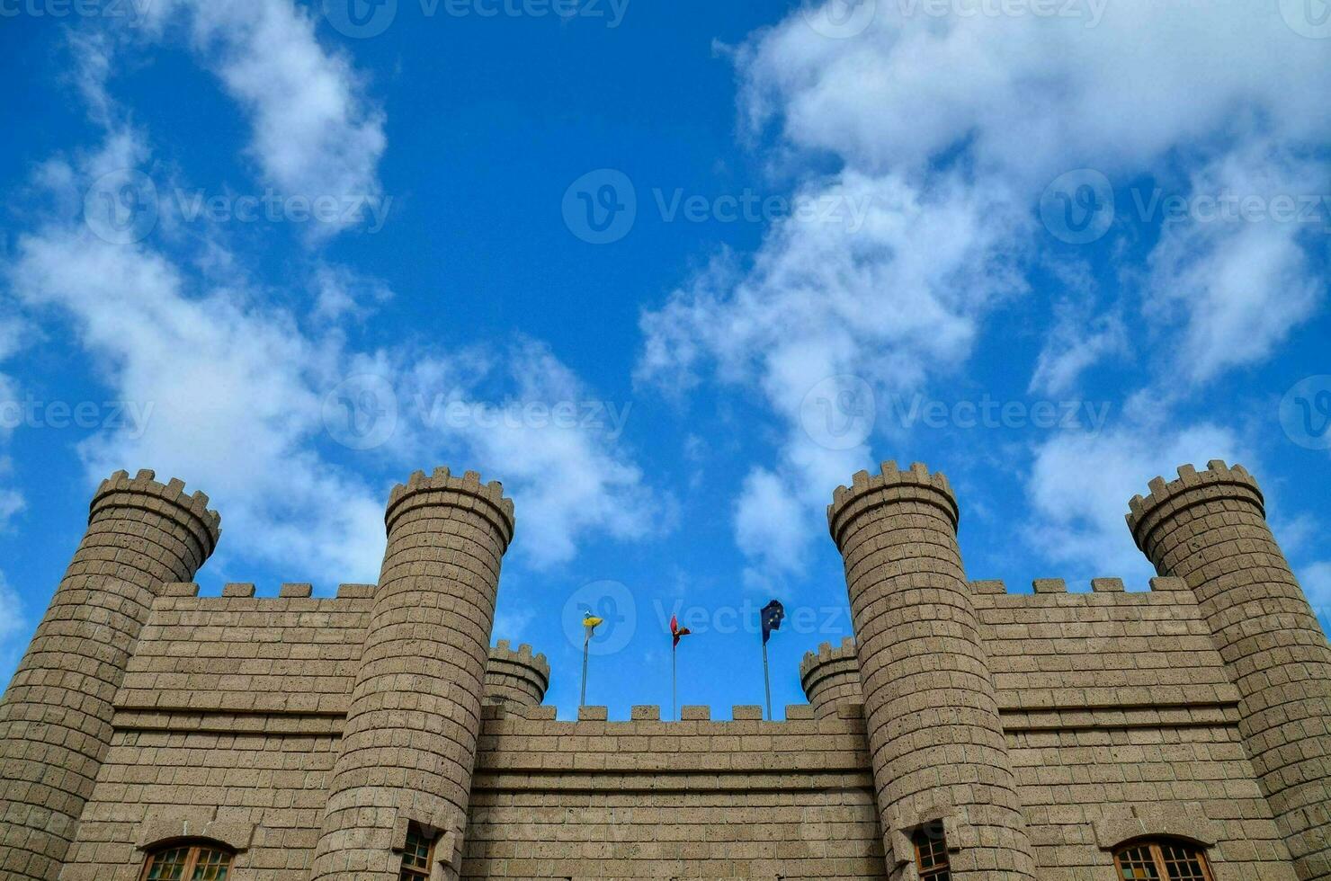 the castle is made of stone and has a blue sky photo