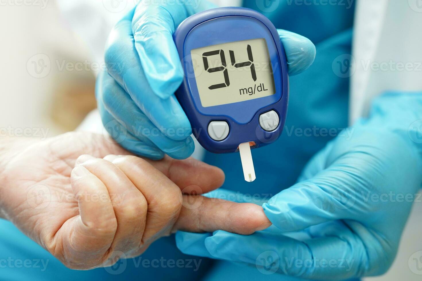 Asian doctor using lancet pen on senior patient finger for check sample blood sugar level to treatment diabetes. photo