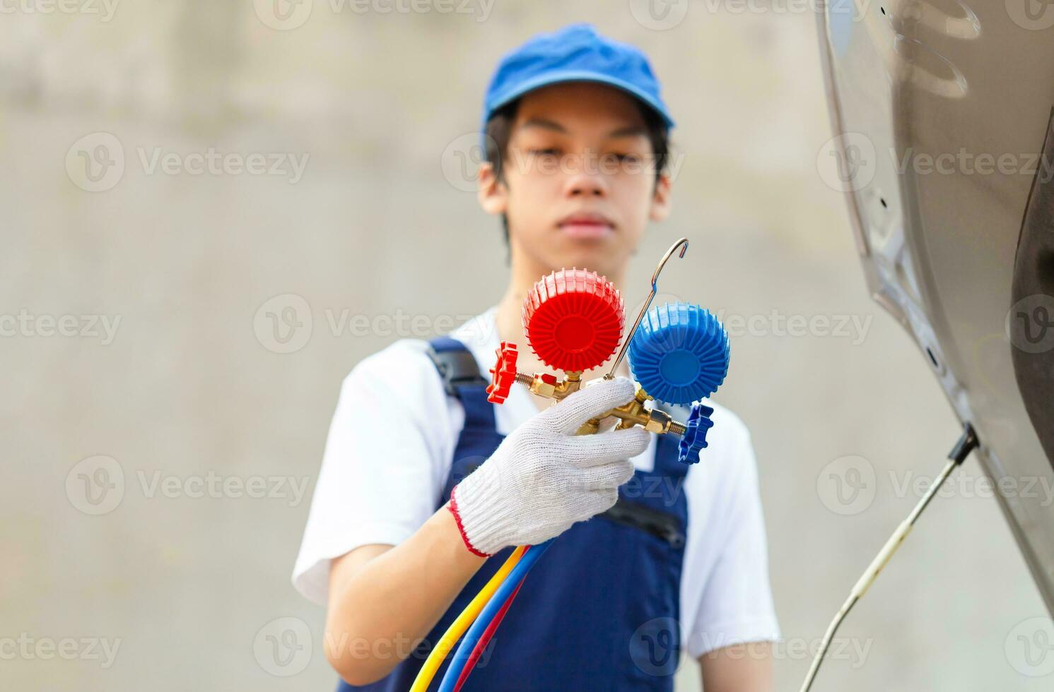 Repairman holding monitor tool to check and fixed car air conditioner system, Technician check car air conditioning system refrigerant recharge, Air Conditioning Repair photo