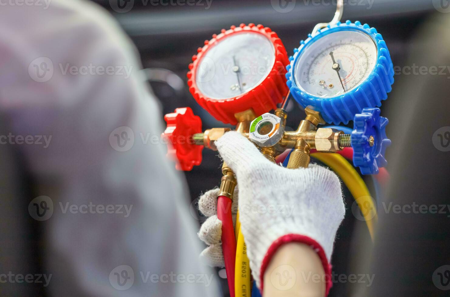 Repairman holding monitor tool to check and fixed car air conditioner system, Technician check car air conditioning system refrigerant recharge, Air Conditioning Repair photo
