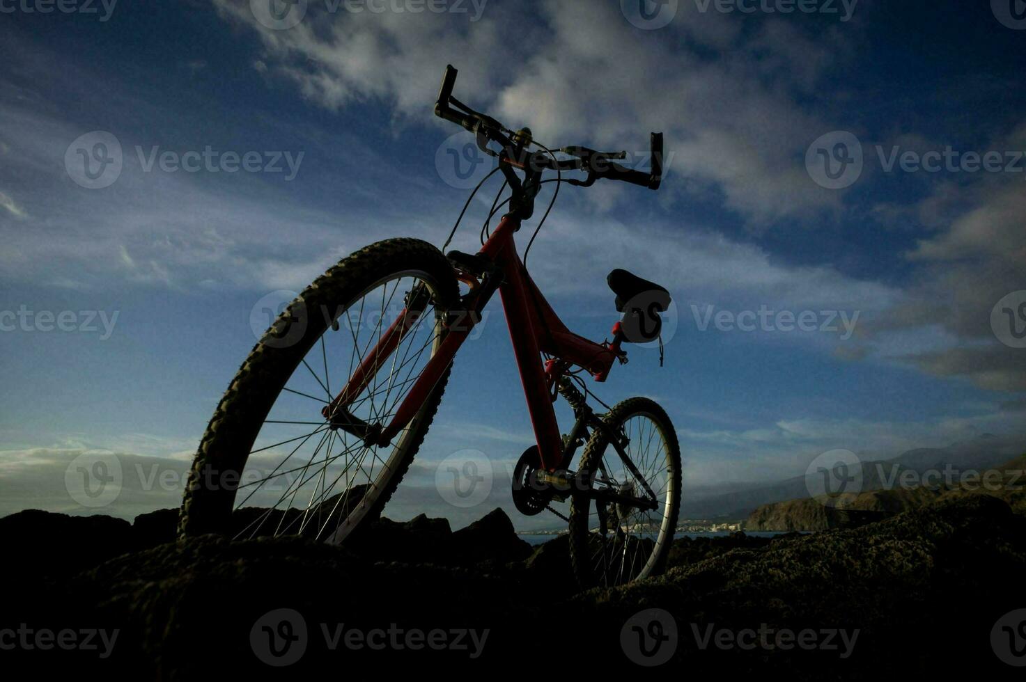 A bike silhouetted against the blue sky photo