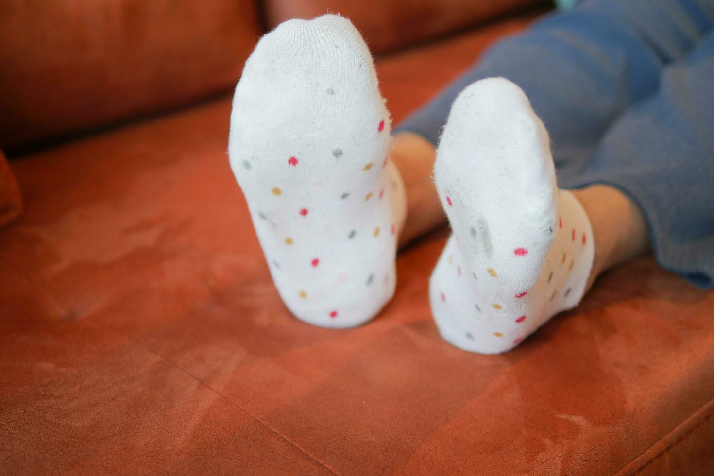 women feet with dirty socks on sofa photo