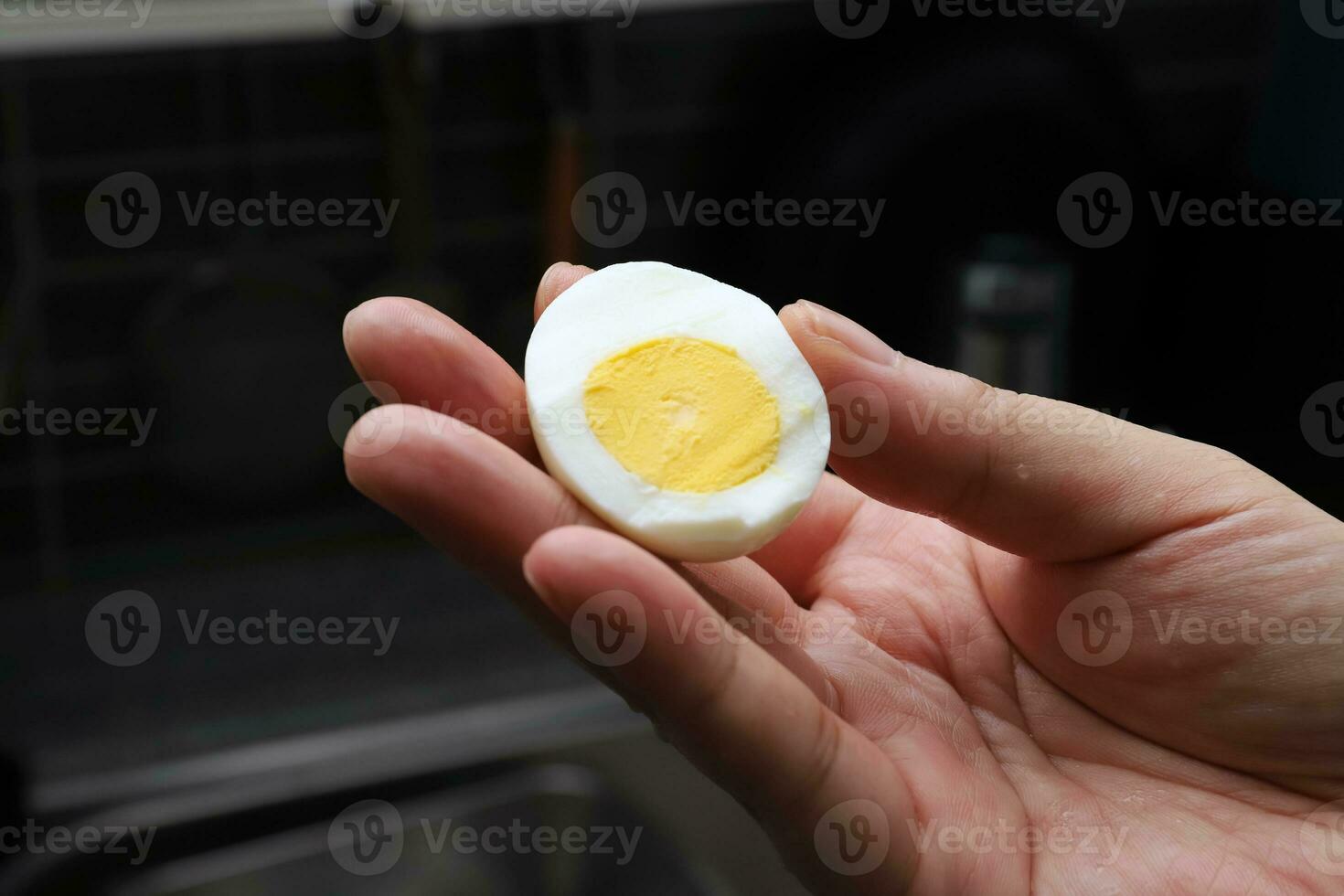 Photo of a human hand holding a boiled egg