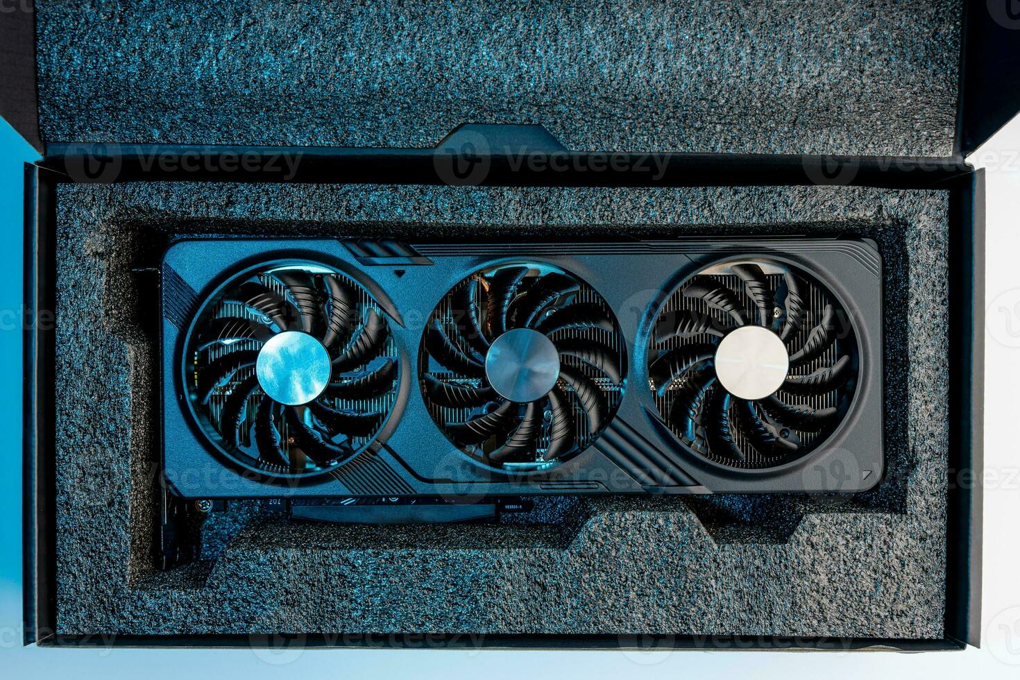 video card for a computer with three fans lies in holders in the shipping box photo