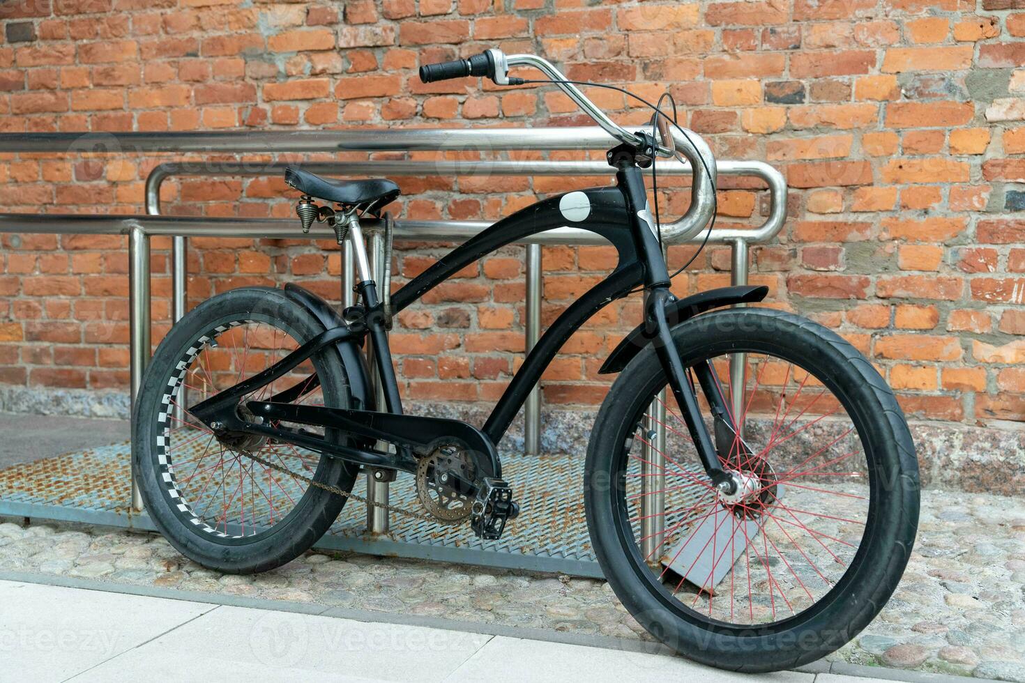 cruiser-style bike is parked against the background of an old brick wall photo